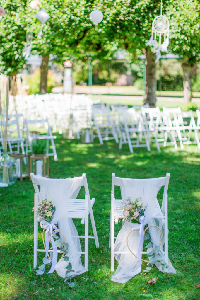 Stühle dekoriert mit Tüll und Rosen für eine freie Trauung im Garten vom Waldhaus in Flims